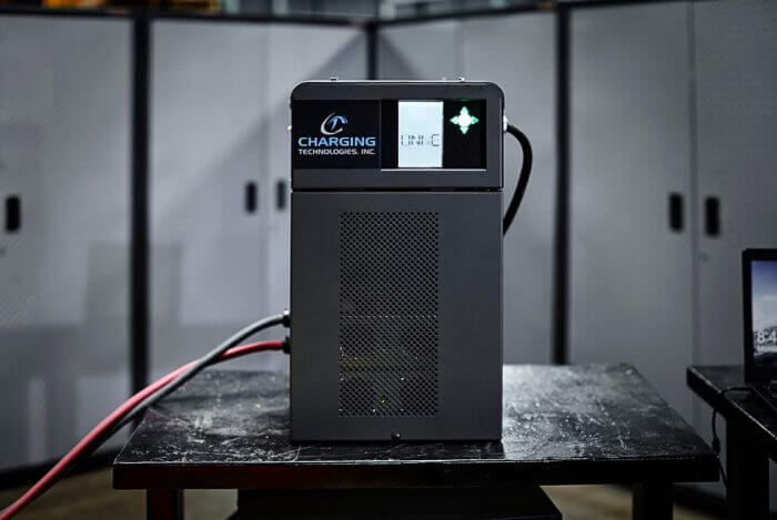 A sleek, vertical grey Charging Technologies Inc. industrial charger with a perforated front cooling vent and a backlit digital status screen.