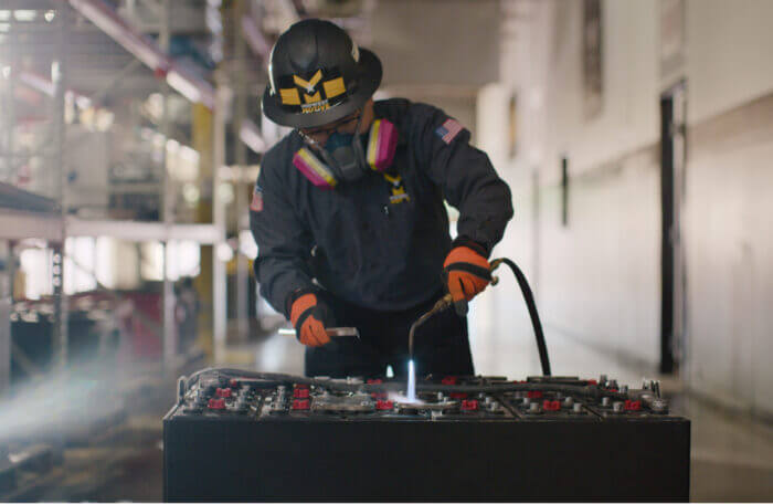 Worker carefully heading battery components as a part of maintenance