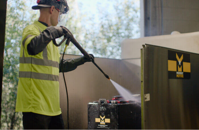 A worker washing a battery