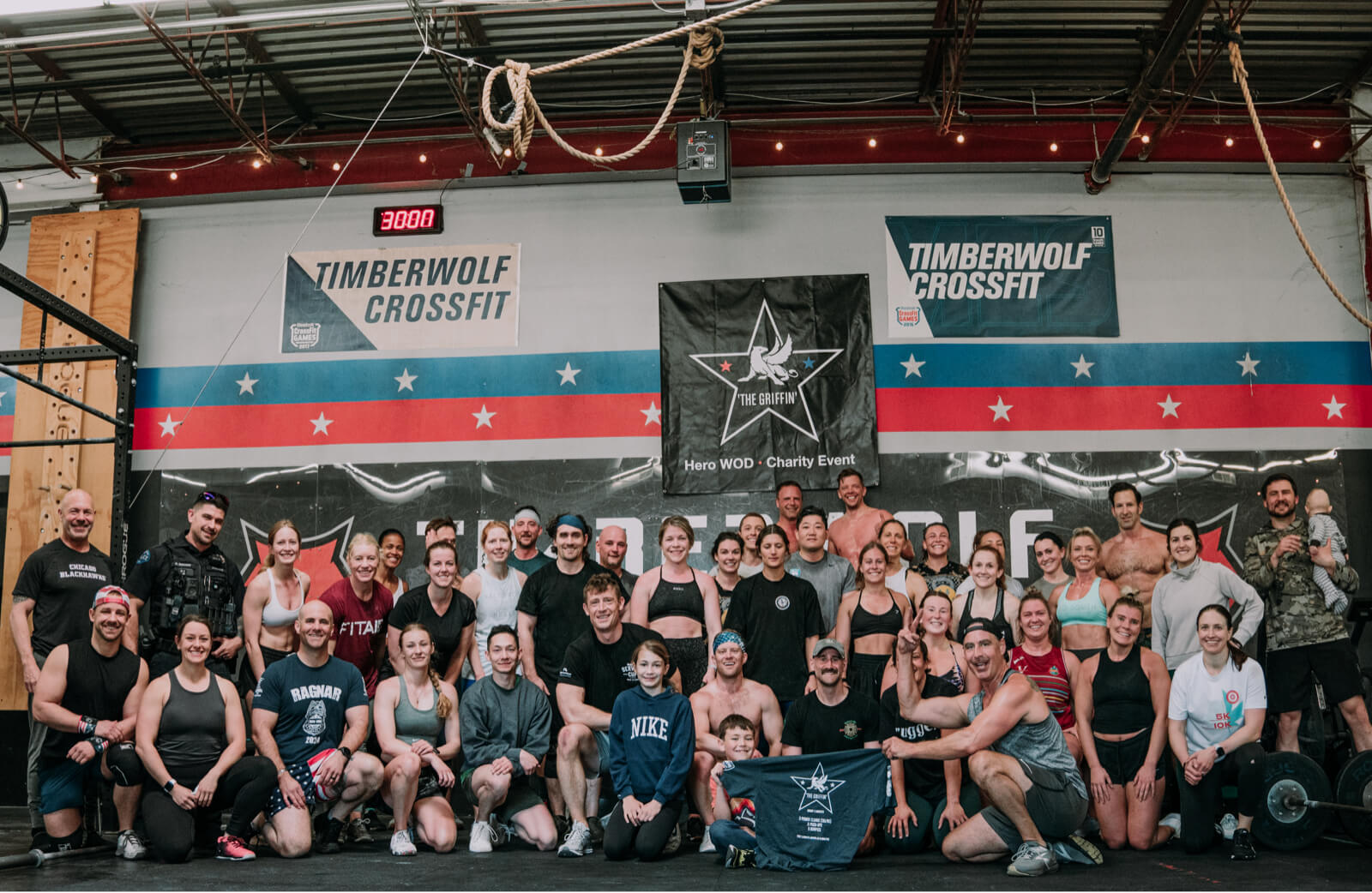 A large group of people posing for a photo in a fitness gym.