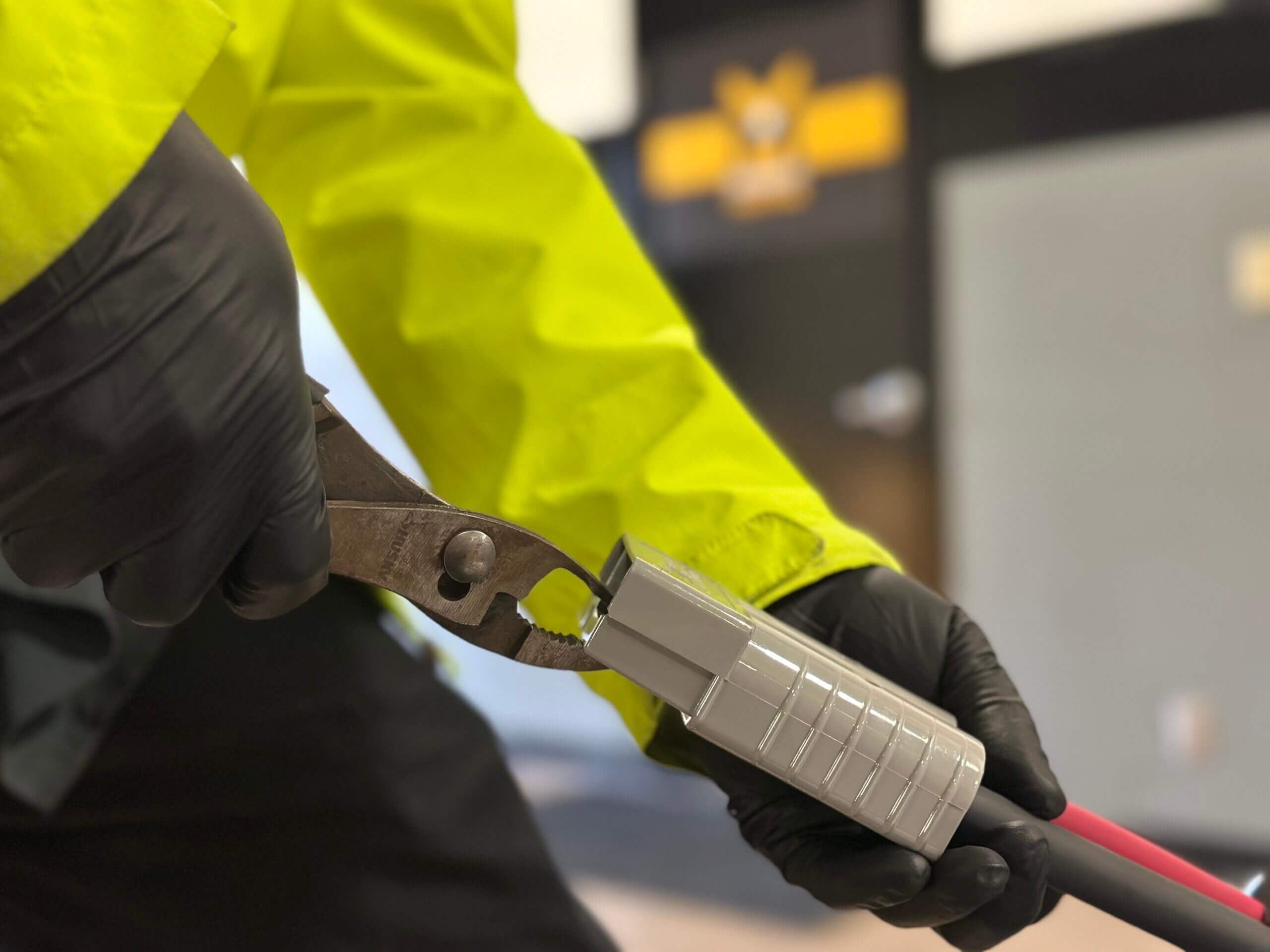 Closeup of a worker using a tool on a cable connector