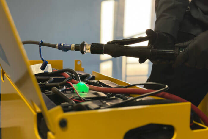 Closeup of a worker's hands while washing industrial battery
